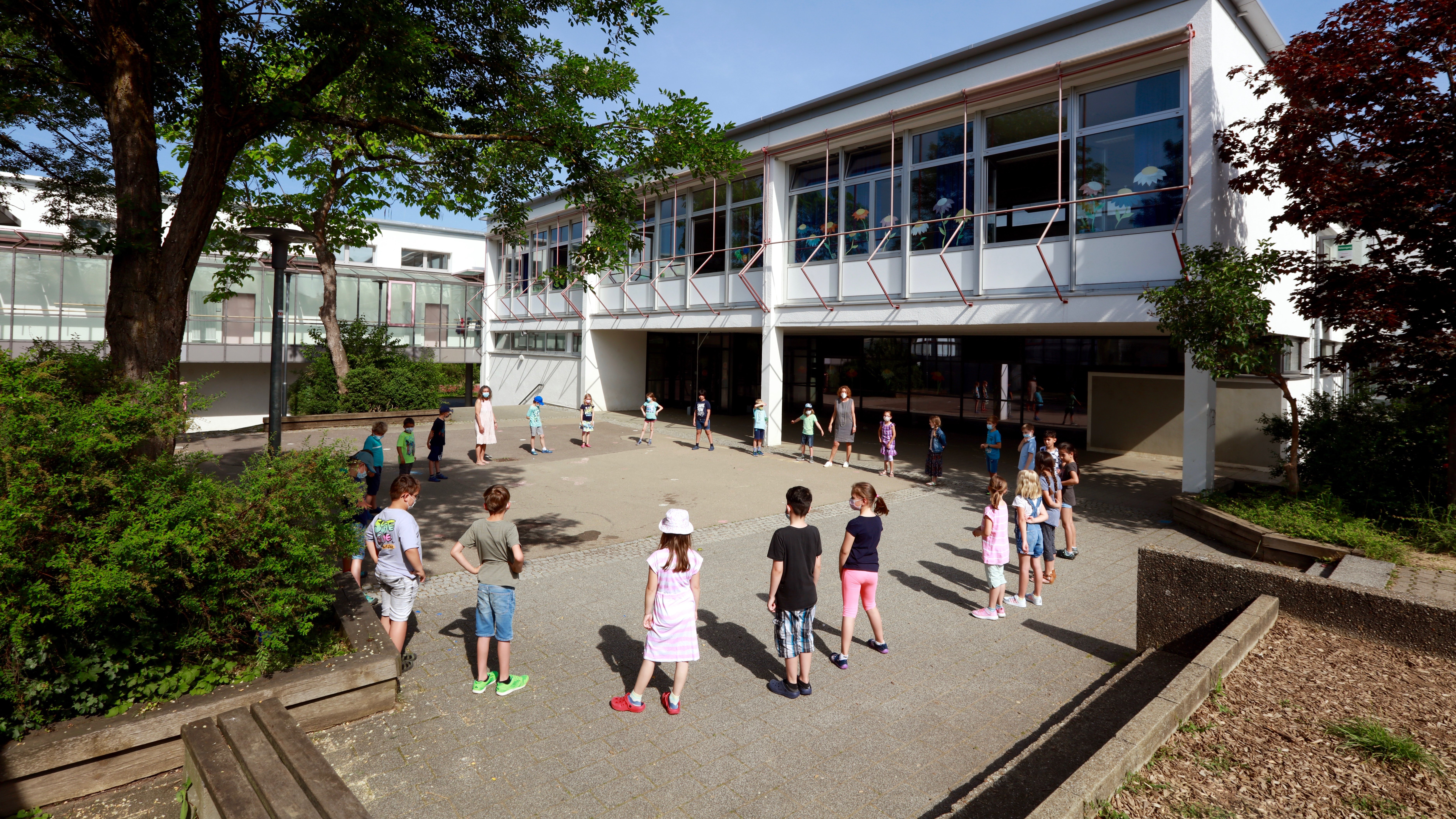 Schüler stehen zusammen in einem Kreis auf dem Schulhof 